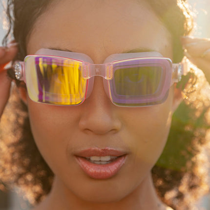 woman wearing vivacity swim goggles in blush pink showing sleek frameless goggles with mirrored lens