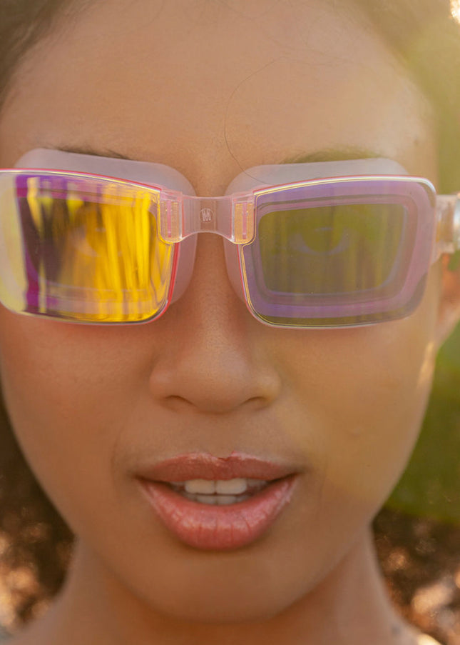 woman wearing vivacity swim goggles in blush pink showing sleek frameless goggles with mirrored lens
