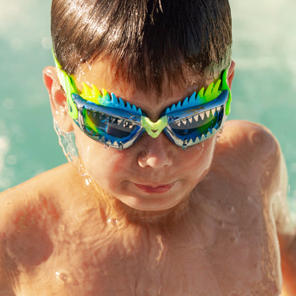 boy swimming getting out of pool wearing draco the dragon kids' swim goggles in sea dragon green showing silicone spiked gasket and sharp teeth printed lens