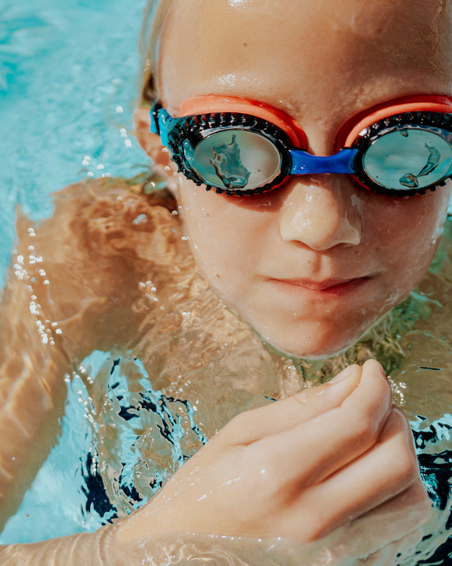 child swimming wearing turbo drive kids' swim goggles in race car red showing car tire tread frame and red gasket