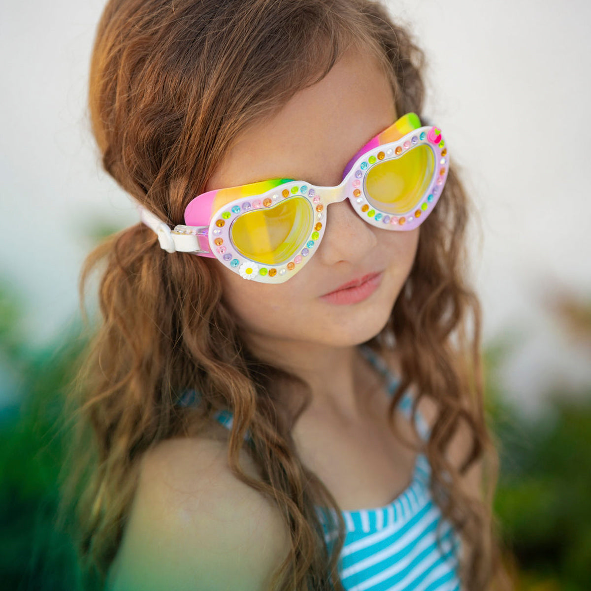 girl wearing bright bouquet of daisies kids heart shaped swim goggles showing rhinestones and flower details with rainbow gasket 