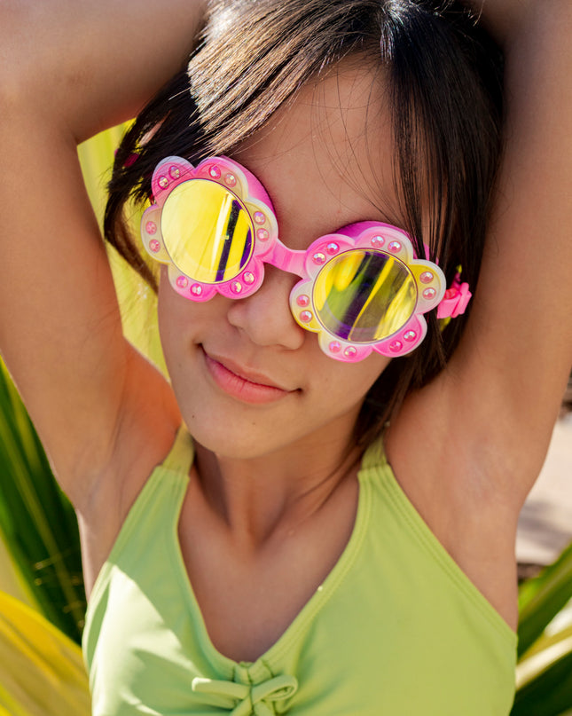 girl smiling posing wearing gardenia flower shaped swim goggles in golden hour showing petal details and rhinestones with mirrored lens