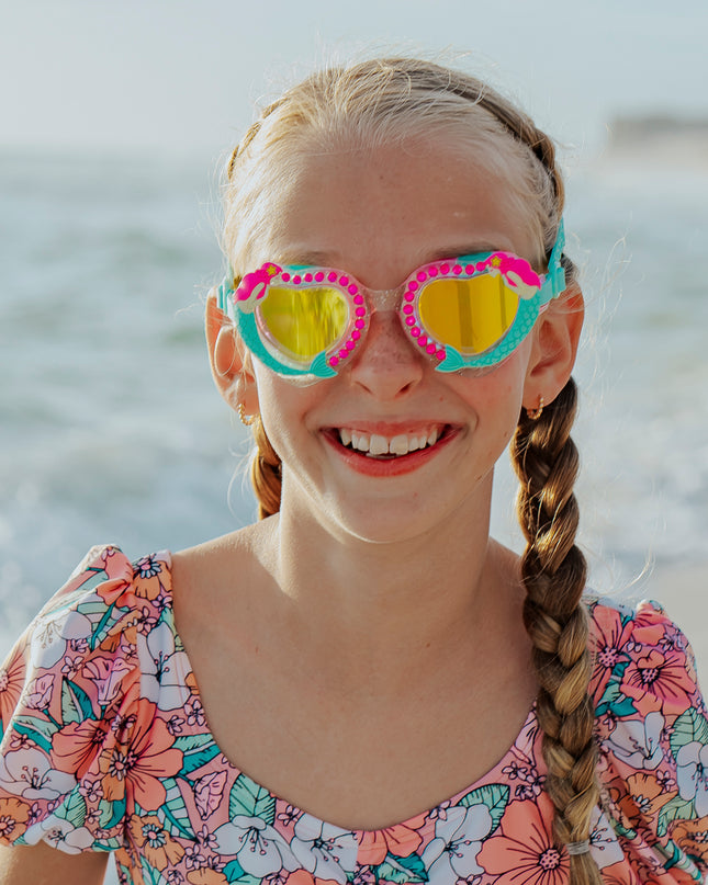 girl at beach wearing mystical mermaid kids' swim goggles showing 3d mermaid detail and rhinestones