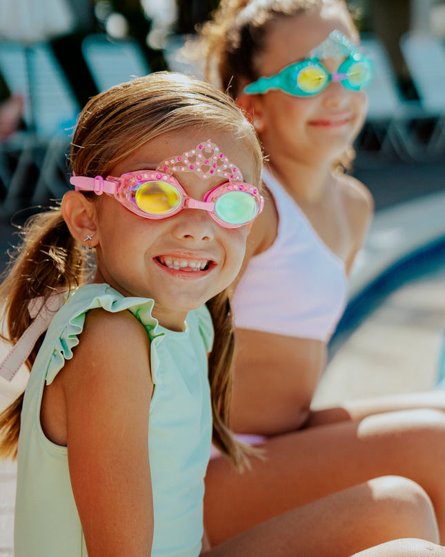 girls sitting poolside smiling wearng royal crown kids' swim goggles showing crown and rhinestone detail