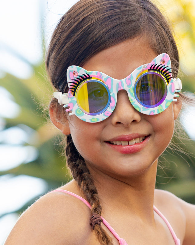 girl smiling wearing savvy cat kids' cat-shaped swim goggles showing cheetah printed frame, faux eyelashes and rhinestones