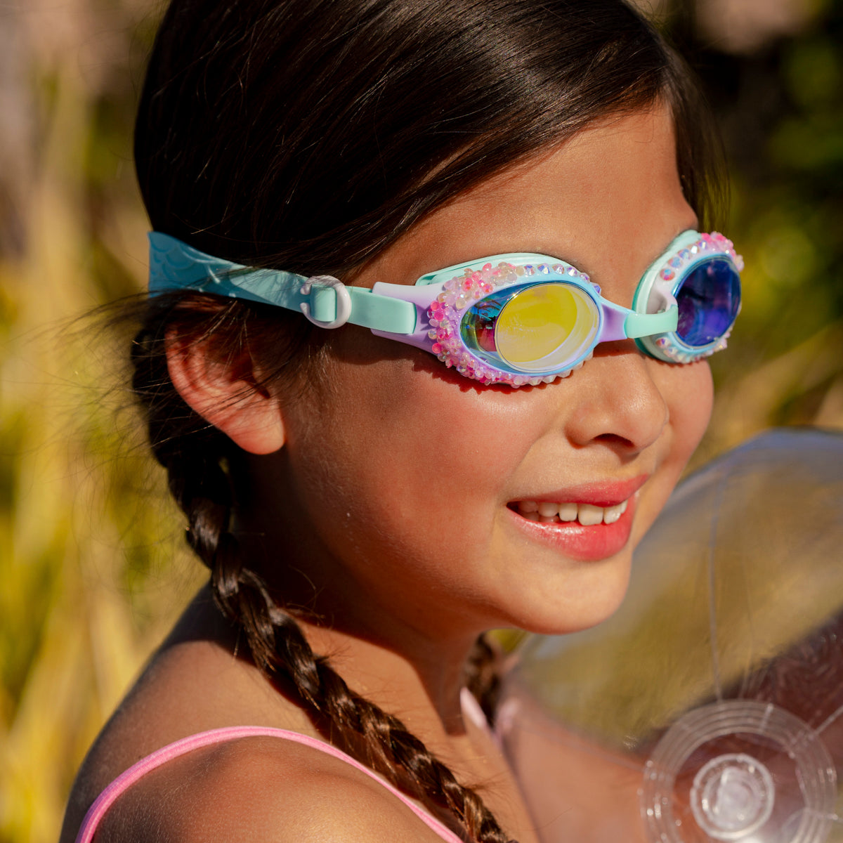 girl smiling poolside wearing seaquin kids swim goggles in seabreeze classic shaped swim goggles showing details of rhinestones and crushed rhinestone details