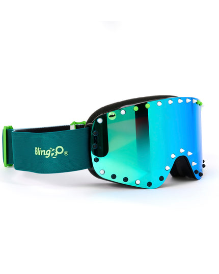 angled shot of prism peak kids' ski goggles in glacier teal featuring a teal mirrored lens, blue strap, green, white and black silicone spikes with decorated monster eye on either side