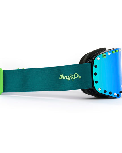 side shot of prism peak kids' ski goggles in glacier teal featuring a teal mirrored lens, blue strap, green, white and black silicone spikes with decorated monster eye on either side showing teal strap