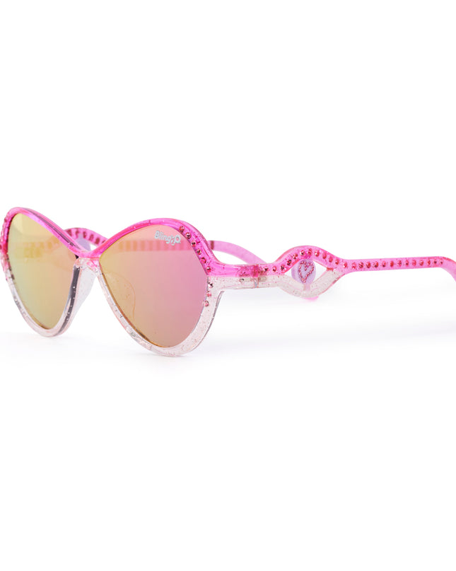 angled product shot of heart beach kids' sunglasses in rosa romance showing a pink and white frame with pink rhinestones on the frame and arm with a heart insignia in a loop on the arm of the sunglass