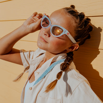 young girl posing wearing malibu beach kids' sunglasses in bay blue showing baby blue frame and detail