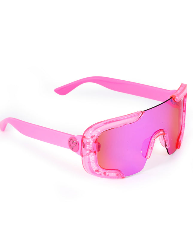 angled product shot of pink sand kids' sunglasses in color sprinkle pink featuring shield frame with 3-d sprinkles in the frame, heart insignia and all pink frame and lens