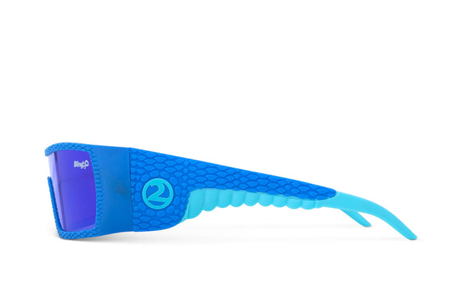 side view of sand harbor kids' sunglasses in sky blue stegosaur showing a sleek frame and dino textured arm of sunglass