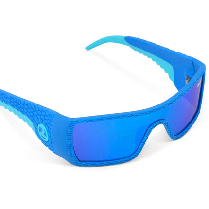 angled view of sand harbor kids' sunglasses in sky blue stegosaur showing a sleek frame and dino textured arm of sunglass