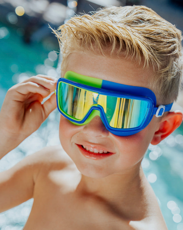 Lifestyle image of boy in front of pool wearing Bypass Blue Beam Kids' Swim Goggles 