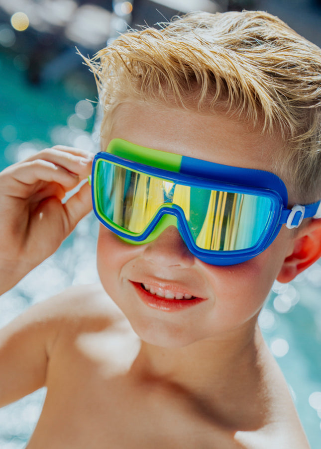 Lifestyle image of boy in front of pool wearing Bypass Blue Beam Kids' Swim Goggles 