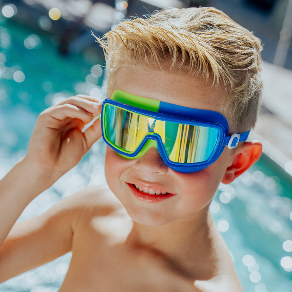 Lifestyle image of boy in front of pool wearing Bypass Blue Beam Kids' Swim Goggles 