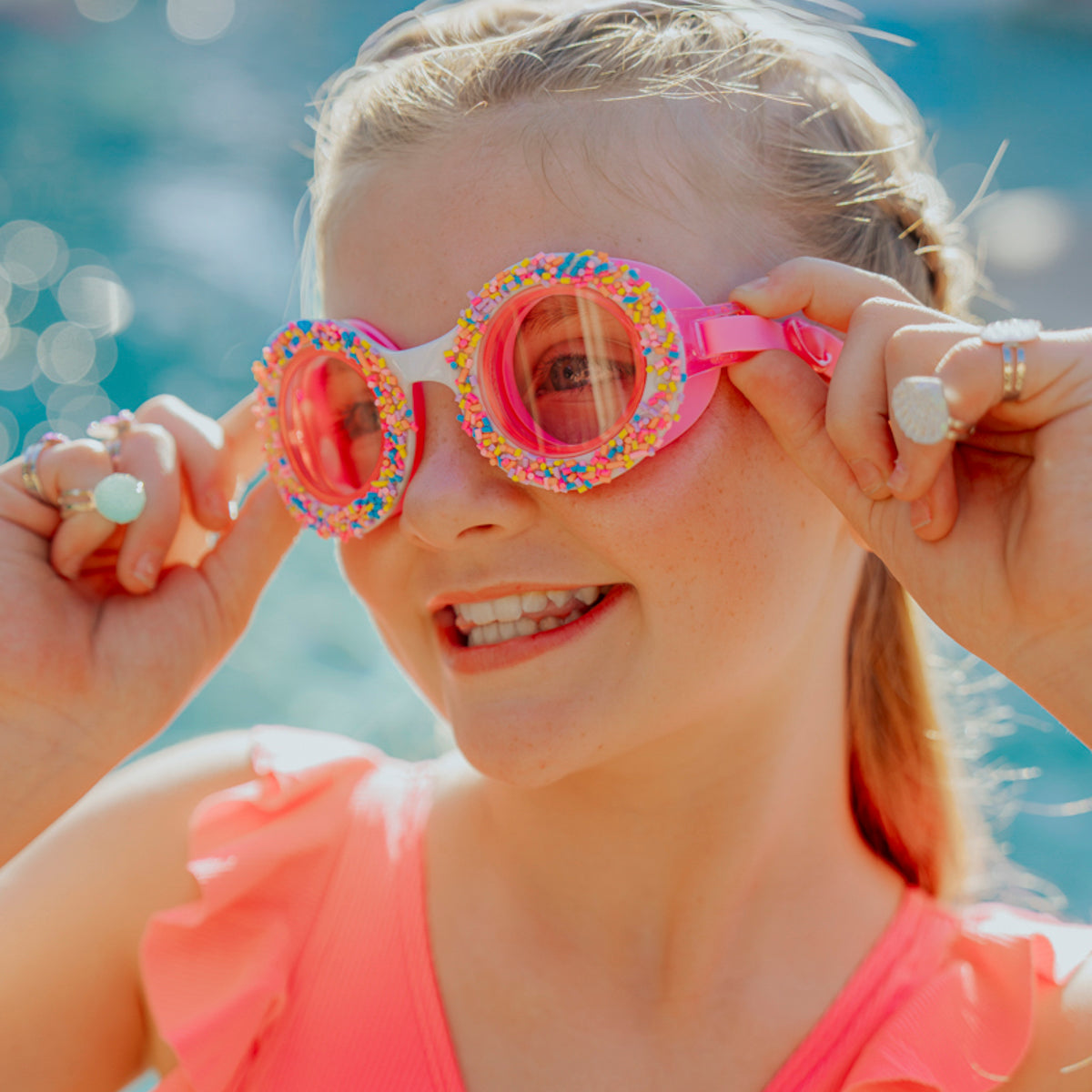 Lifestyle of girl wearing donuts 4 u swim goggles in boston creme pink showing sprinkles and pink silicone