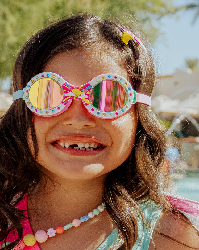 girl smiling standing in front of pool and sprinkler wearing sunrise sparkle showing round frame with sunrise detail and rhinestones