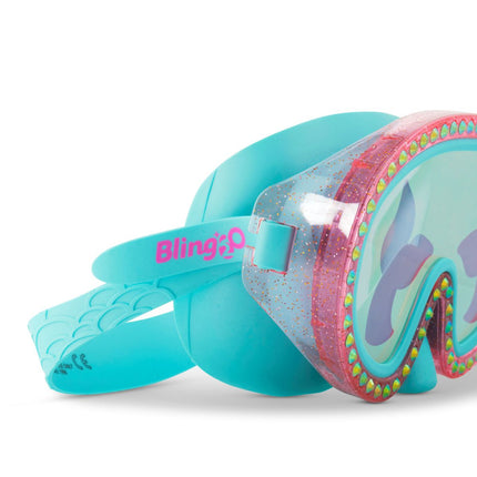 close-up of blue sea kids' swim mask with nose piece in blue sushi colorway showing reflective translucent mermaid tail print lens on rhinestone glitter frame