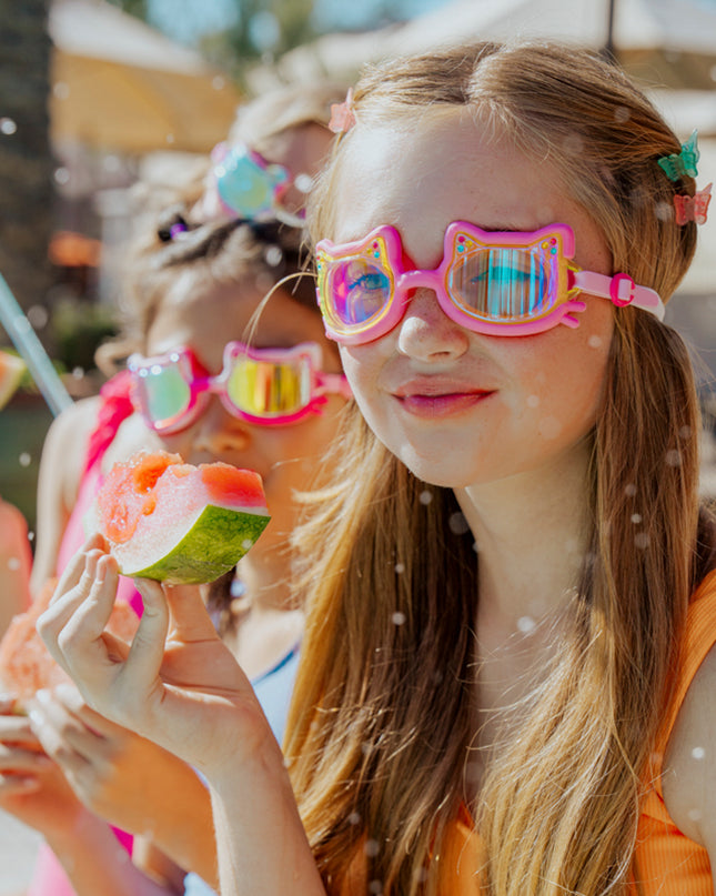 lifestyle of girl taking snack break next to pool in flexi feline kids swim goggles 