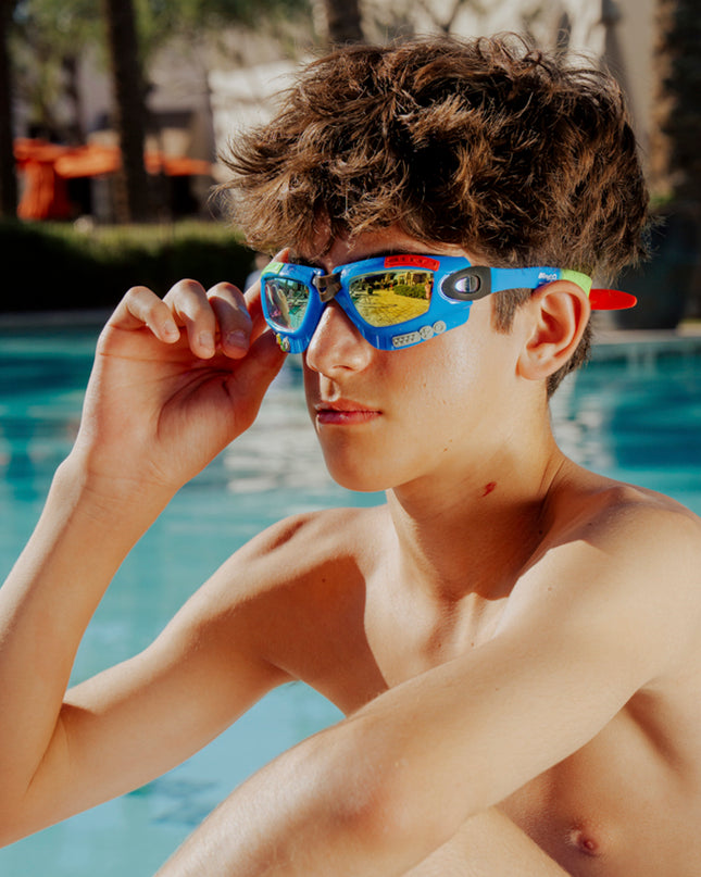 lifestyle of model poolside wearing gamer kids swim goggles in console cobalt blue showing gaming details on frame