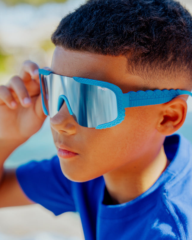 lifestyle of kid wearing gulfshore kids sunglasses in crocodile cobalt blue showing texture on frame and arm