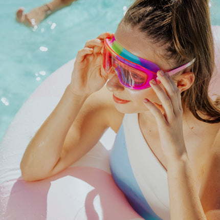 lifestyle of girl wearing hologlow swim goggles in pixel pink showing hot pink frame and swirl colored gasket
