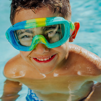 lifestyle of boy in pool swimming wearin hologram swim goggles in cyber green showing frameless lens and swirls of green silicone gasket