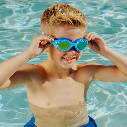 lifestyle of boy in pool smiling and posing wearing jurassic dive in raptor reef blue showing silicone spike detail