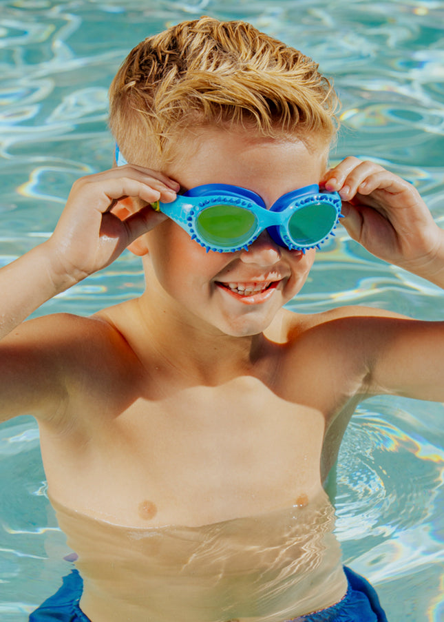 lifestyle of boy in pool smiling and posing wearing jurassic dive in raptor reef blue showing silicone spike detail