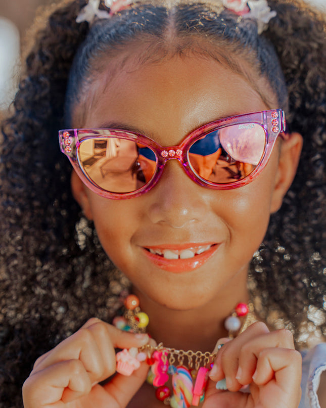 lifestyle of girl wearing malibu kids sunglasses in misty magenta showing purple frame and rhinestones