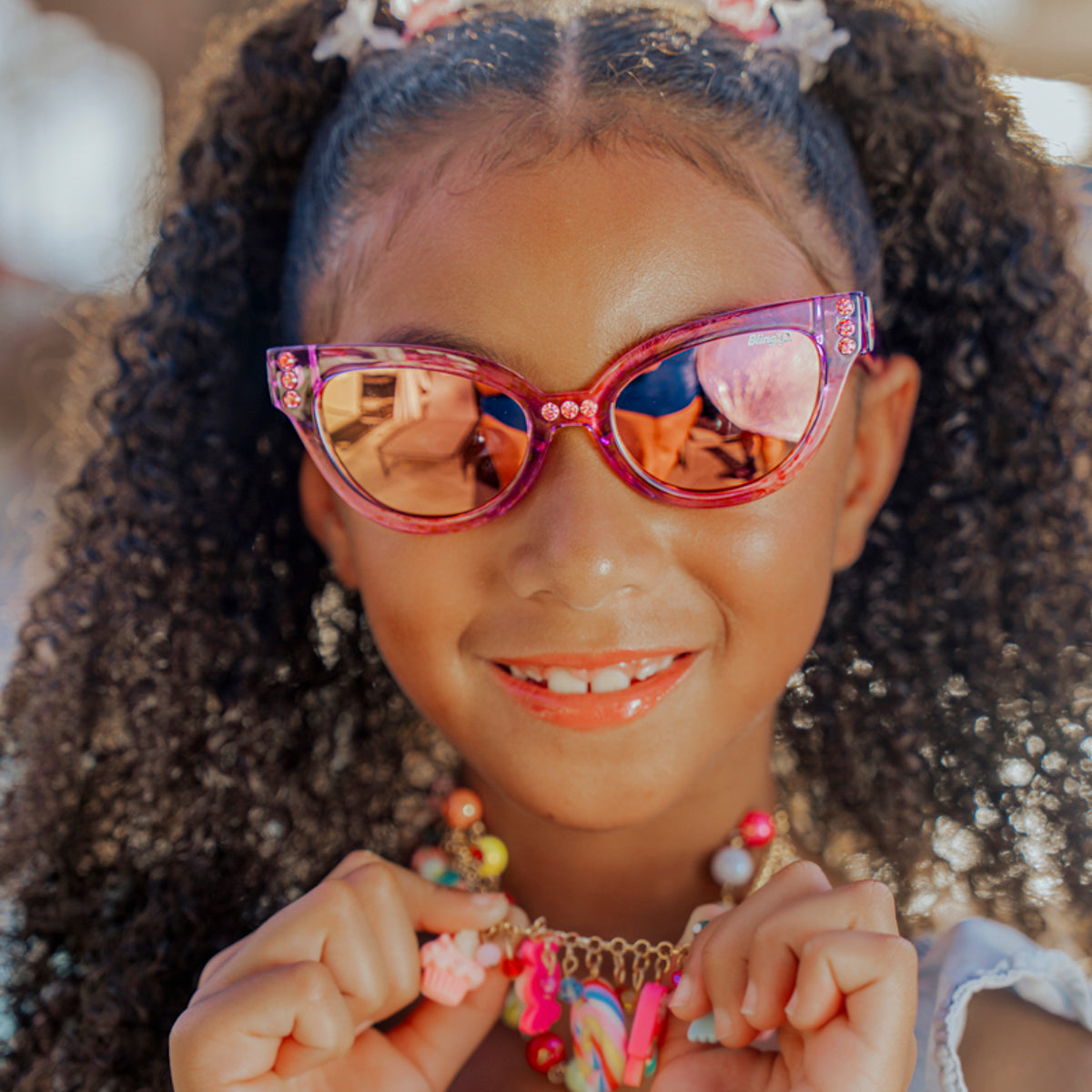 lifestyle of girl wearing malibu kids sunglasses in misty magenta showing purple frame and rhinestones