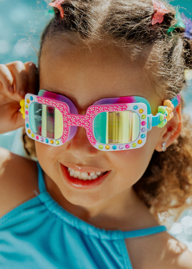 Lifestyle of 4 year old girl smiling wearing Pretty Girl Poppy in Petal Pop Pink kids' swim goggles 