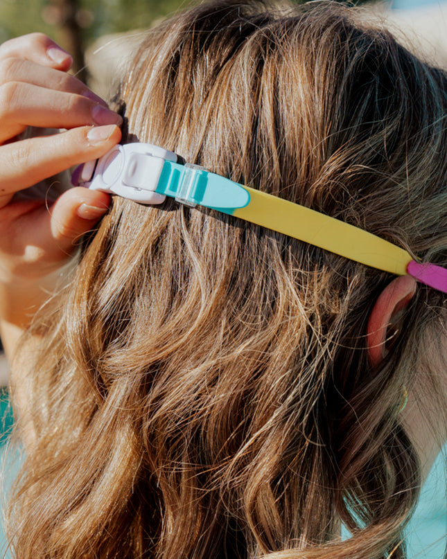back view of girl wearing tie-dye tabby all silicone cat shaped swim goggles showing back clip