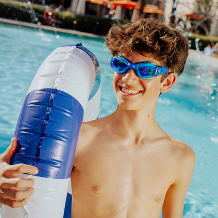 teen boy smiling standing poolside holding inner tube wearing voyage swim goggles showing reflective lens and silicone frame