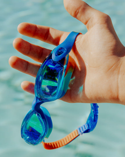 voyage swim goggles in trailblaze being held showing all silicone frame and tinted lens