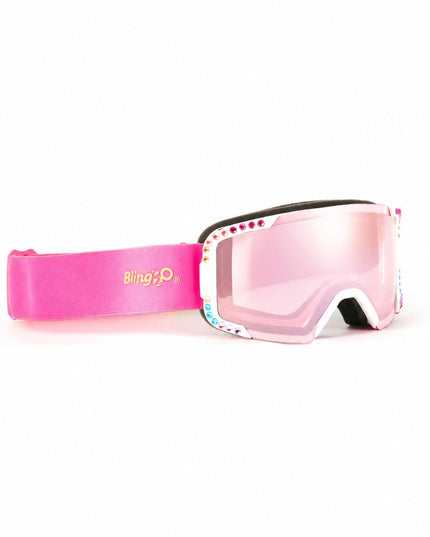 angled product shot of powder pop kids' ski goggles in prism powder showing pink mirrored lens and rainbow rhinestones around white frame with hot pink and blue strap
